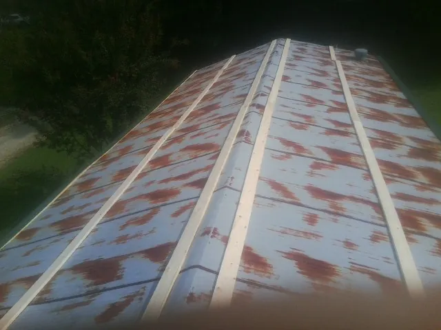 Rusted metal roof panels with new wood purlins before replacement — Storm Damage Roof Repair in La Fontaine by Roofing Brothers