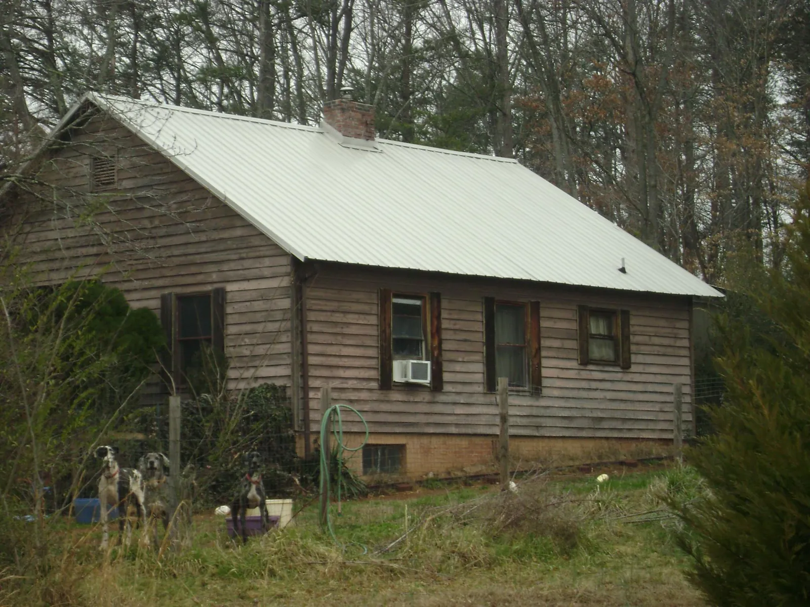 White metal roof on an old wood sided farmhouse, from a Metal Roof Installation job in La Fontaine