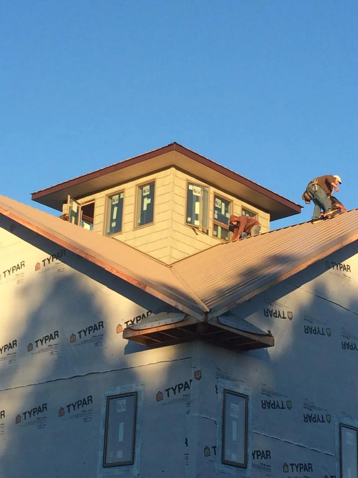 Roofers working around a rooftop cupola on a new metal roof at sunset — Roof Waterproofing in La Fontaine by Roofing Brothers